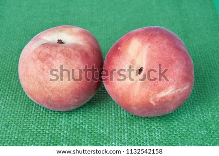 Ripe delicious peach fruit on a green wicker cloth