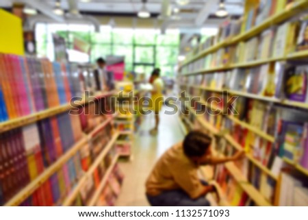 Blurry perspective picture of book shop with people choosing a book, two big shelf of various pocketbook, educate, novel, history, green nature out of glass window, back to university concept