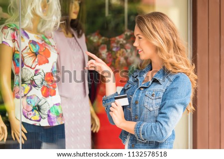 Beauty woman with credit card before the shop