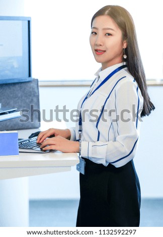 Beautiful asian female white collar standing and using computer