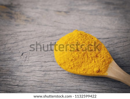 Turmeric powder on wooden background.with copy space.