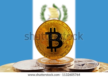 Bitcoin BTC on stack of cryptocurrencies with Guatemala flag in background. The cryptocurrency coin is golden and in focus