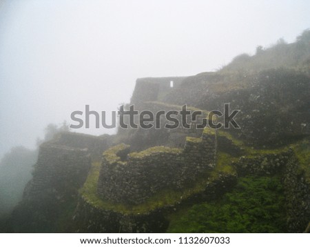 Ruins of mysterious Inca ruins lost in nature with fog at dawn. Machu Picchu. Peru. No people.