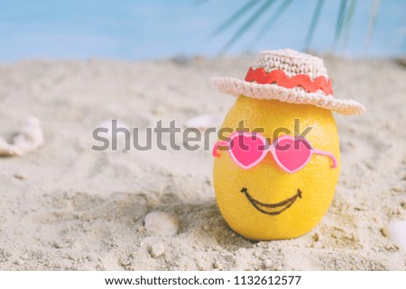 Creative minimal summer idea. Lemon citrus hipster in pink sunglasses and bamboo hat on sand. Tropical beach concept. Creative art. Fun party Mood. Copy space