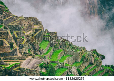 The secret and mysterious ruins of Machu Picchu covered in mist with the high Andes mountains on the background. The amazing prize of hiking the Inca Trail in Peru, South America.