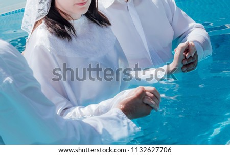 Two pastors baptize girl Royalty-Free Stock Photo #1132627706