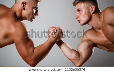 Two men arm wrestling. Rivalry, closeup of male arm wrestling. Two hands. Muscular men measuring forces, arms. Hand wrestling, compete. Hands or arms of man. Muscular hand. Clasped arm wrestling.