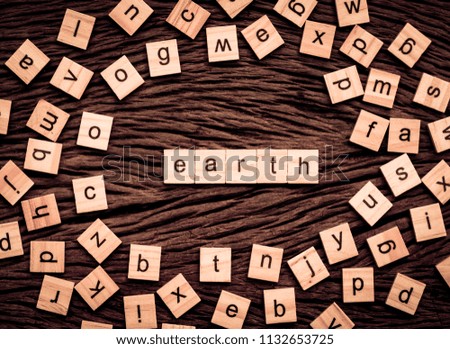 Earth word written cube on wooden background. Vintage concept.