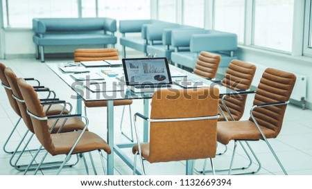 open laptop computer with financial charts and papers spread out on the desktop before starting business negotiations