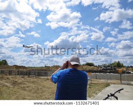 Guy Boy Man Standing and Making Pictures Photographs of a Flying Plane