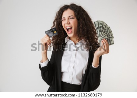 Photo of excited happy young business woman with credit card and money isolated over white wall backgound.