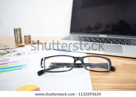 The eyeglasses of a business on a wooden table in a business concept.