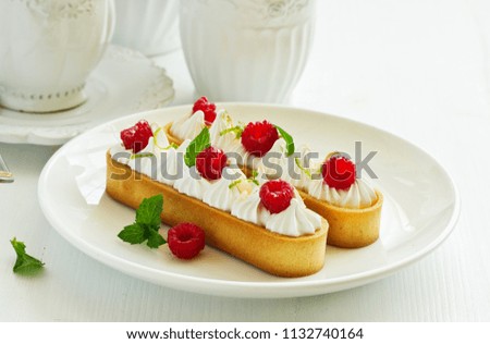 Lemon pie with meringue and raspberries.