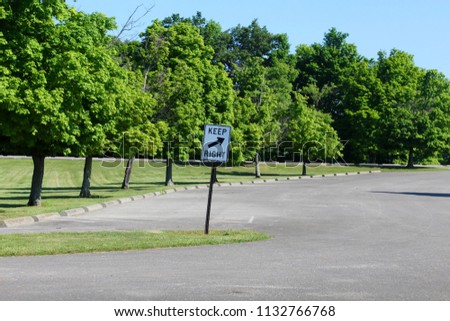 The keep right sign in the parks parking lot on a sunny day.