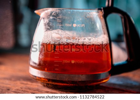 modern glass kettle with brewing on an old wooden table