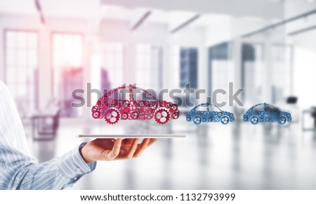 Car icon made of gears and cogwheels on white office background. Mixed media