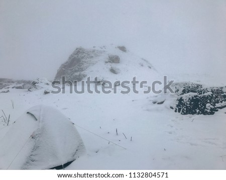 tent in extreme winter conditions covered with snow high in the mountains