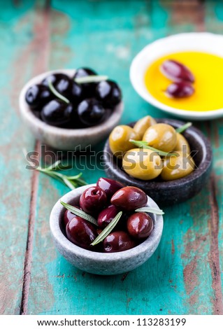 Kalamata, Green and Black Olives with Fresh Rosemary and Olive Oil on rustic wooden background. Concept for a tasty and healthy appetizer. Royalty-Free Stock Photo #113283199