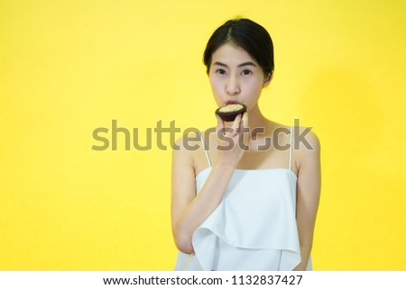 Young Asian Woman with Slave egg on yellow background, isolated