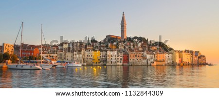Colorful sunset of Rovinj town, Croatian fishing port on the west coast of the Istrian peninsula. Colorful evening seascape of Adriatic Sea. Traveling concept.