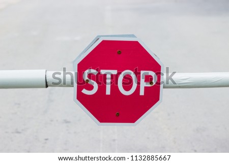 Stop sign on the barrier. Close-up.