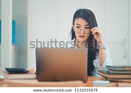 Beautiful businesswoman working with laptop at modern office