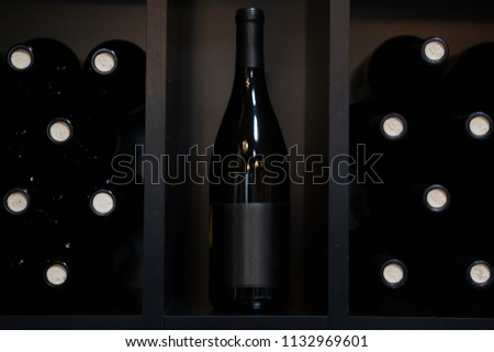 Blank Labeled Red Wine Bottles on A shelf Royalty-Free Stock Photo #1132969601