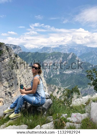 Girl with thermos sitting on a rock near breakage Grlo Sokolovo, Montenegro nature canyon near Korita village