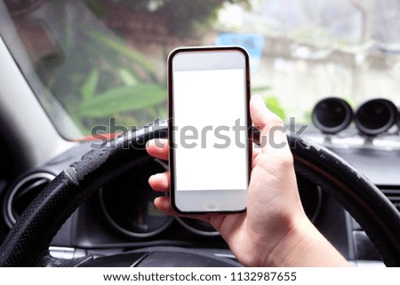 Closeup of hand holding smart phone in a car
