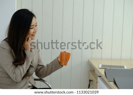 A businesswoman holds a brown coffee mug and prepares information for the meeting.