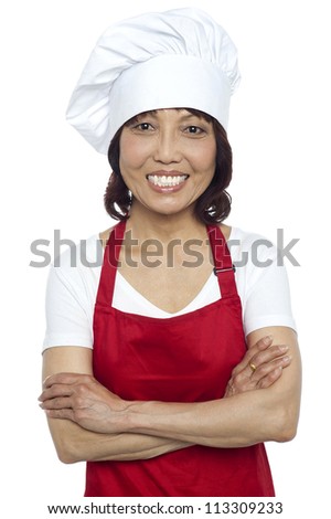 Confident smiling chef posing with her arms crossed isolated over white