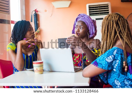 group of young african women discussing something important. three african women discussing business. group of young women discussing together  Royalty-Free Stock Photo #1133128466