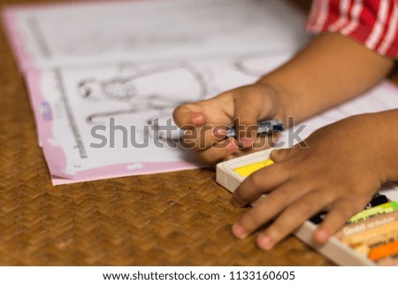 a young boy take homework, painting color on a picture