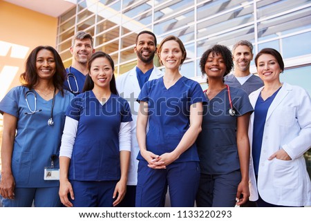 Smiling medical team standing together outside a hospital Royalty-Free Stock Photo #1133220293