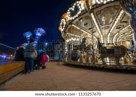 Children's vintage Carousel at an amusement park in the evening and night illumination. Beautiful, bright carousel in Alicante, Spain