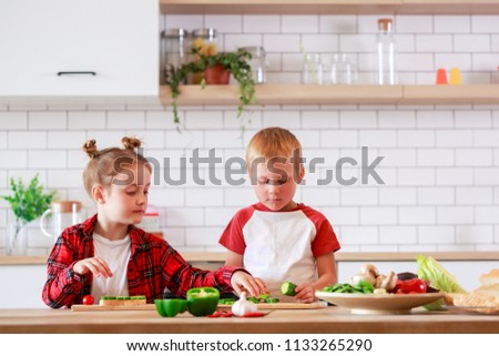 Photo of girl and boy cooking vegetables