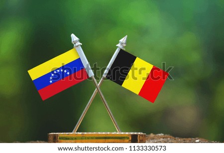 Belgium and Venezuela small flag with blur green background