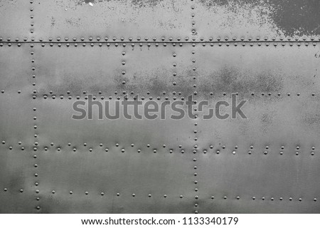 Old silver metal surface of the aircraft fuselage with rivets Royalty-Free Stock Photo #1133340179