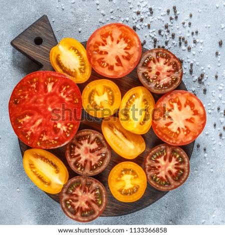 Sliced multi-colored tomatoes for salad or side dish - red, orange, yellow and black. Selective focus and square picture