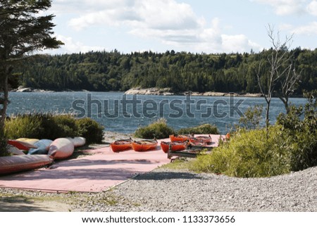 Camping in canada with access to the river and canoes in the sun. Red canoes in the sun in the middle of the Canadian forest