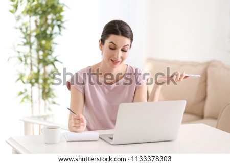 Young female freelancer working with laptop at home