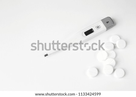 White pills and thermometer. Flat lay. The concept of medicine, disease, health.