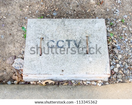 Cement cover of cctv control line in the urban garden.