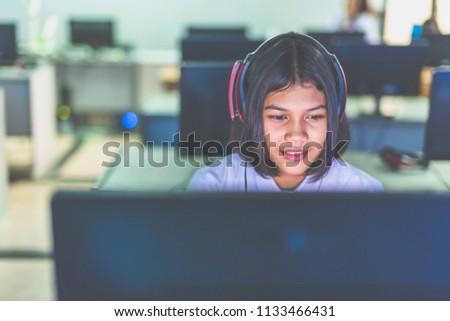 Female high school student is enjoying social media in computer room, Thailand , southeast Asia.(Matte style image)