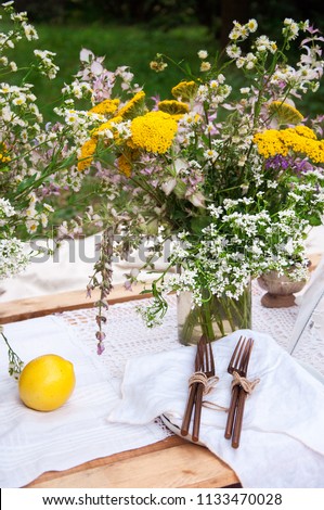 Summer brunch table setting (forks and knives) lemon and dried flowers