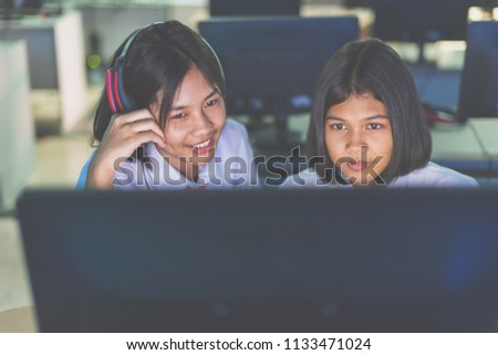 Female high school students are enjoying social media in computer room, Thailand , southeast Asia.(Matte style image)