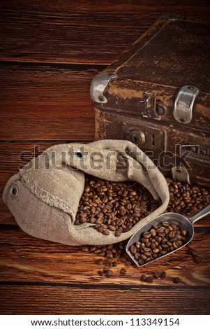 Fresh coffee beans on wood and linen bag, ready to brew delicious coffee