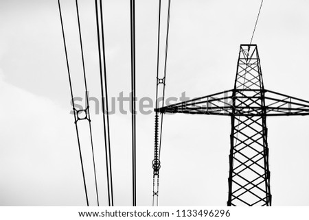 Close-up of top of electricity pylon against cloudy sky