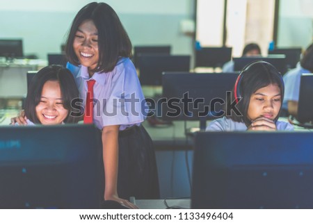Female high school students are enjoying social media in computer room, Thailand , southeast Asia.(Matte style image)