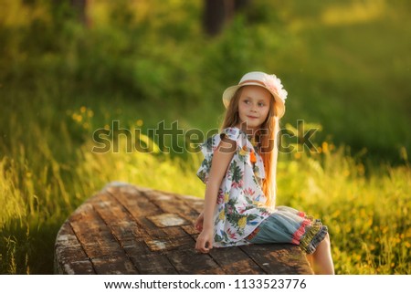 Portrait of a cute beautiful girl with a hat in a summer forest